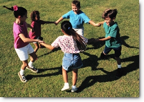 Young children holding hands and running in a circle